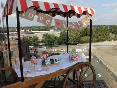 Liebevoll eingerichteter Ziehkarren zu einer Hochzeitsveranstaltung mit dem oben angebrachten Schriftzug "Love is sweet"